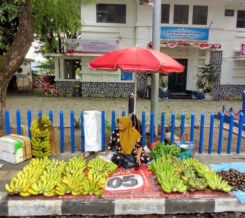 Seorang Warga Gampong Paya Seunara, Berjualan Pisang Di Atas Trotoar Untuk Membiayai Kebutuhan Hidup Sehari Hari